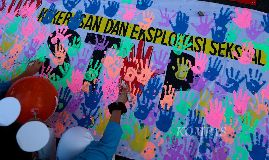 Peserta aksi menuliskan pesan dukungan terhadap kampanye antikekerasan dan eksploitasi seksual kepada anak di Jalan Slamet Riyadi, Kota Surakarta, Jawa Tengah, Minggu (24/7/2022). 