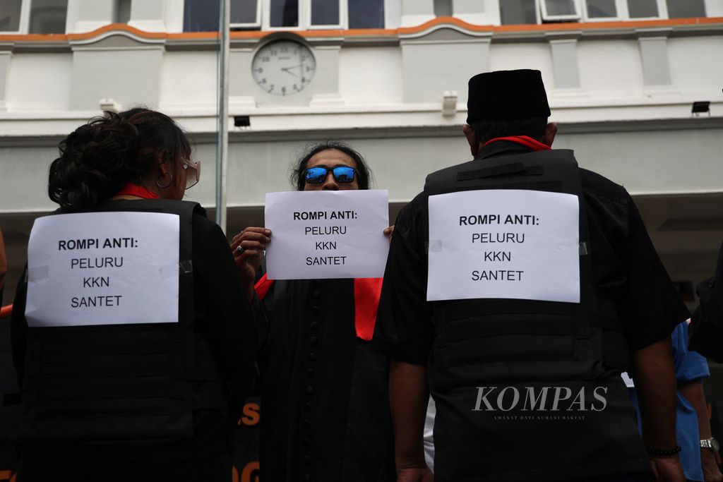 Pengunjuk rasa yang tergabung dalam Gerakan Rakyat untuk Demokrasi dan Keadilan (Garda) menggelar aksi pengiriman rompi antipeluru untuk hakim Mahkamah Konstitusi di depan Kantor Pos Besar, Yogyakarta, Rabu (3/4/2023).