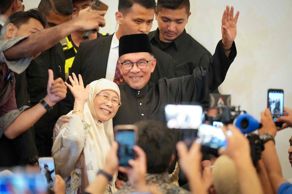 Malaysia's newly appointed prime minister Anwar Ibrahim (C) and his wife Wan Azizah waves as they arrive ahead of his address at a gathering in Kuala Lumpur, Malaysia on November 24, 2022. - Reformist politician Anwar Ibrahim was sworn in as Malaysia's 10th prime minister on November 24, ending a days-long political impasse after an inconclusive weekend election. 