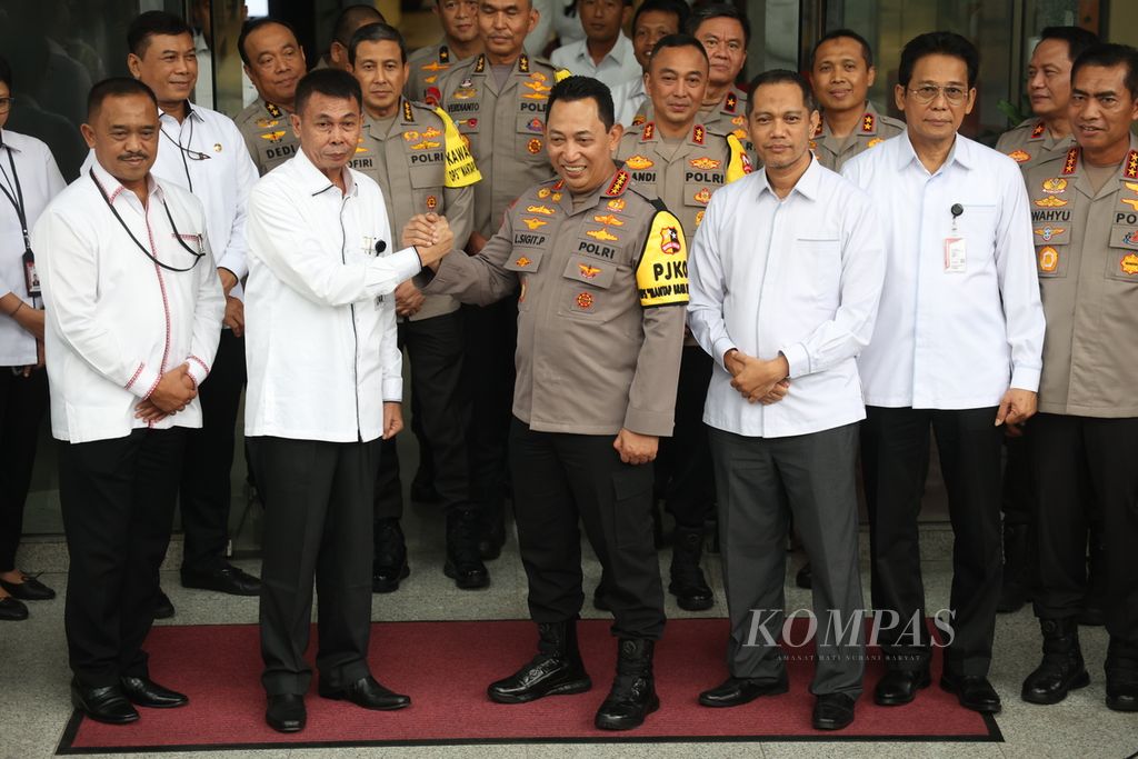 Kapolri Jenderal (Pol) Listyo Sigit Prabowo (tengah) bersama Ketua Komisi Pemberantasan Korupsi (KPK) Nawawi Pomolango (dua dari kiri) bersalam komando seusai memberikan keterangan kepada wartawan setelah pertemuan di Gedung KPK, Jakarta, Senin (4/12/2023). 