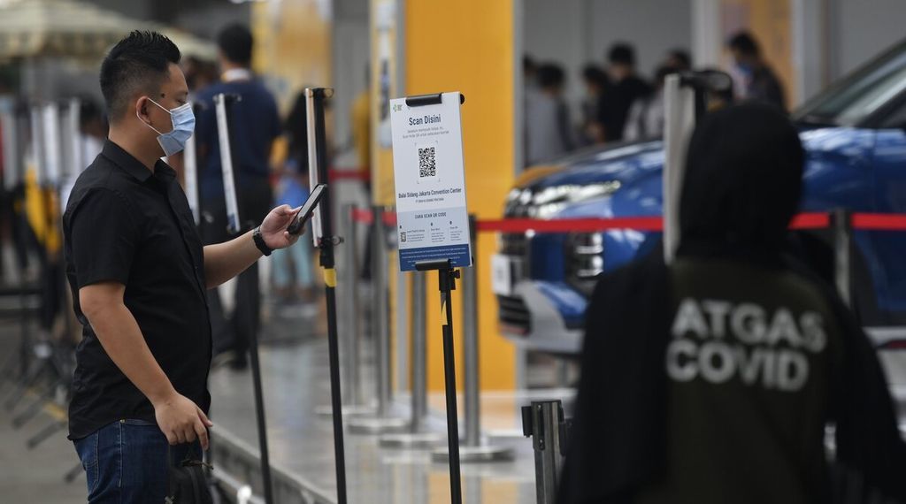 Pengunjung memindai aplikasi Peduli Lindungi di pintu masuk pameran otomotif Jakarta Auto Week yang berlangsung di Jakarta Convention Center, Jakarta, Minggu (13/3/2022). 