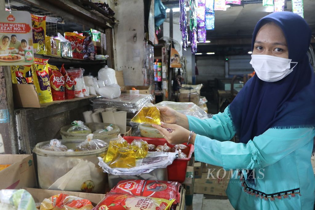  A trader shows the bulk cooking oil that buyers are currently looking for after the price of packaged cooking oil rose to Rp 22,450 per liter at Petisah Market, Medan, North Sumatra, Thursday (17/3/2022)..