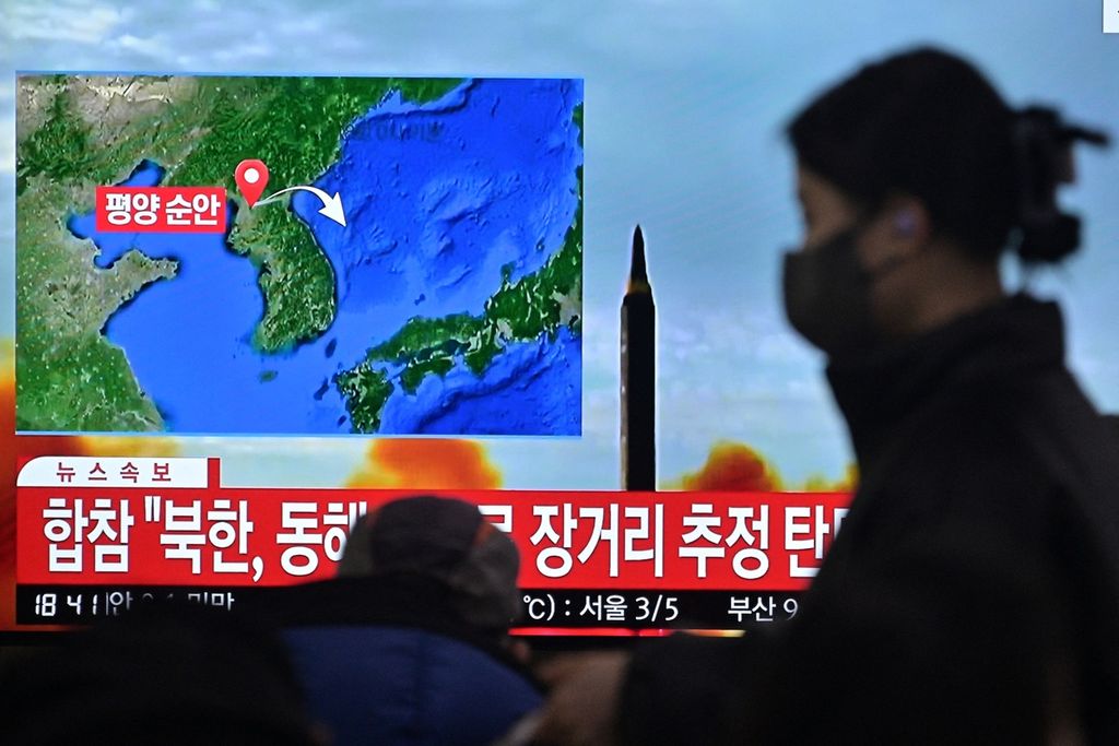 Seorang pejalan kaki melewati sebuah layar yang tengah menyiarkan informasi tentang peluncuran rudal balistik Korea Utara di sebuah stasiun kereta di Seoul, Korea Selatan, Sabtu (18/2/2023). Korea Utara menyebut peluncuran ini memperlihatkan bahwa wilayah Pasifik berada dalam jarak tembak rudal-rudal mereka. ( Anthony WALLACE / AFP)