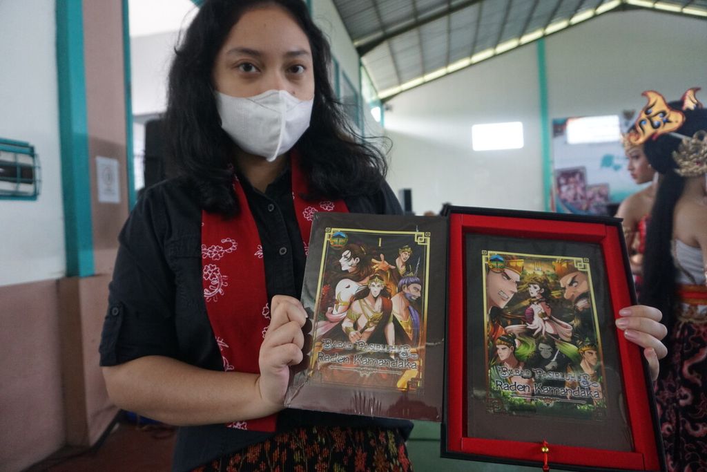 Maria Rengganis atau Megan (24) menunjukkan dua jilid komik <i>Babad Pasirluhur Raden Kamandaka</i> di Desa Tamansari, Karanglewas, Banyumas, Jawa Tengah, Sabtu (19/11/2022).