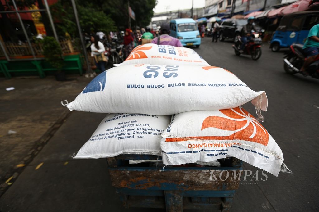 Buruh pikul membantu mendistribusikan beras Bulog ke kios-kios pedagang pada operasi pasar dalam rangka menjaga Ketersediaan Pasokan dan Stabilitas Harga (KPSH) beras, minyak goreng, dan gula pasir di pasar Kebayoran, Jakarta Selatan, pada 25 September 2019.