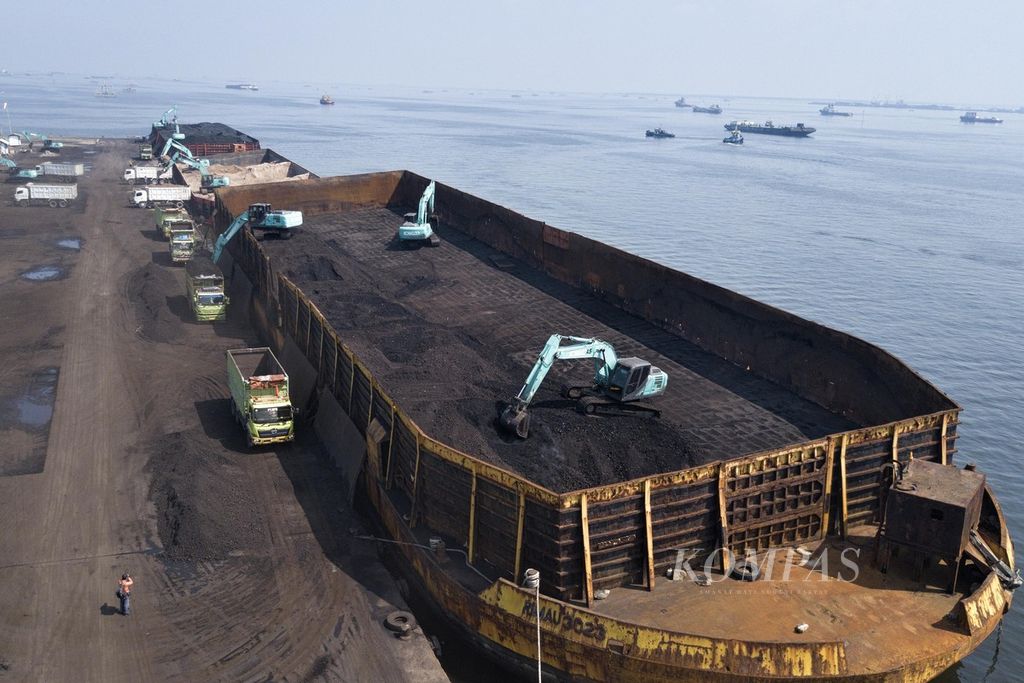 Ekskavator memindahkan batubara yang didatangkan dari Kalimantan dari dalam tongkang ke atas truk di Pelabuhan KCN Marunda, Jakarta Utara, Rabu (5/1/2022).