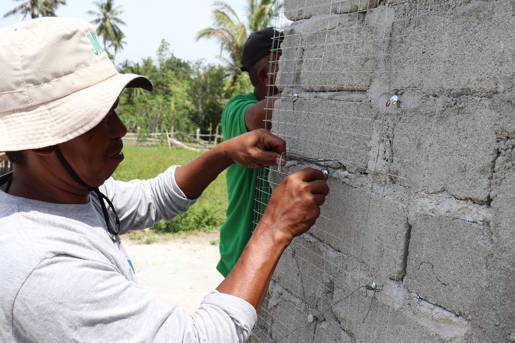 Seorang tukang memasang kawat pada dinding sebuah rumah untuk menghasilkan rumah tahan gempa dalam pelatihan di Desa Rogo, Kecamatan Dolo Selatan, Kabupaten Sigi, Sulteng, awal Desember 2019. 