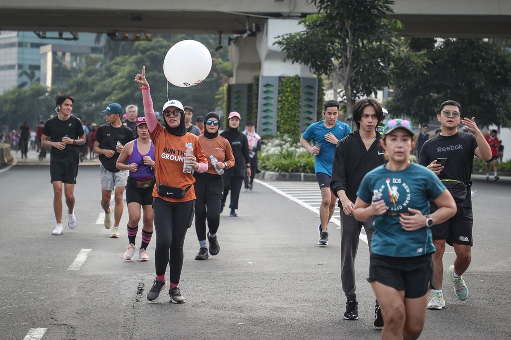 Anggota komunitas Skolari berlari di Jalan Jenderal Sudirman, Jakarta, Minggu (14/5/2023). 