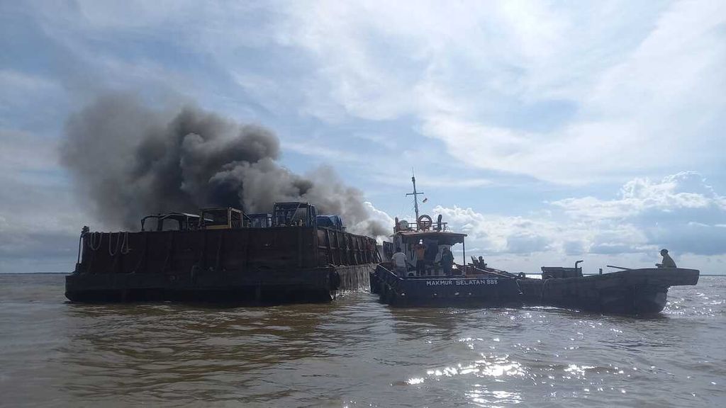 Tongkang yang membawa 12 alat berat terbakar di Kampung Laut, Kabupaten Tanjung Jabung Timur, Jambi, Senin (19/12/2022) sore. Seorang awak kapal mengalami luka, sedangkan enam awak lainnya berhasil dievakuasi. 
