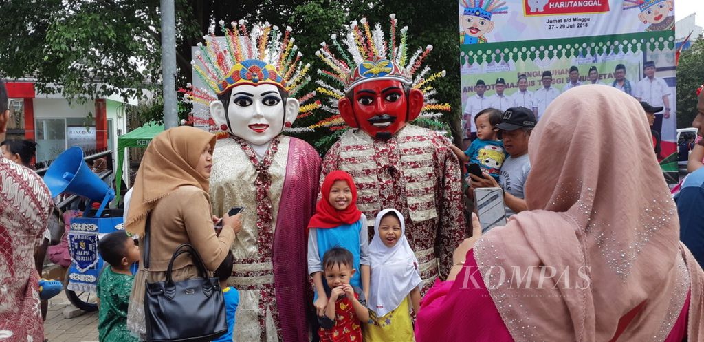 ILUSTRASISuasana kegembiraan keluarga yang berbondong-bondong di hari terakhir Lebaran Betawi di Perkampungan Budaya Betawi Setu Babakan, Jakarta Selatan (29/7/2018).