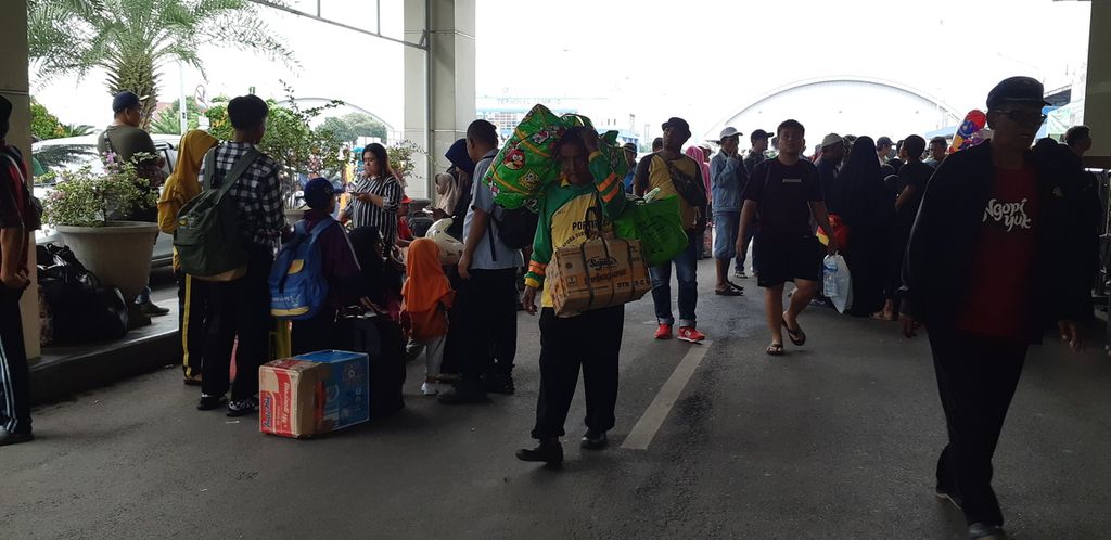 Seorang kuli angkut di Gapura Surya Tanjung Perak, Surabaya, membantu membawa barang milik penumpang Kapal Motor Labobar, Rabu (8/3/2023). Mereka menerima upah Rp 200.000 hingga Rp 250.000 per penumpang 