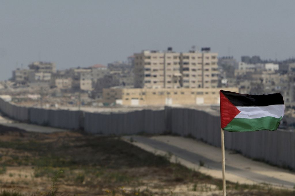 Bendera Palestina terpasang dengan latar belakang tembok di sepanjang Koridor Philadelphia, perbatasan antara Mesir dan Rafah, Jalur Gaza selatan, 1 Juli 2007. 