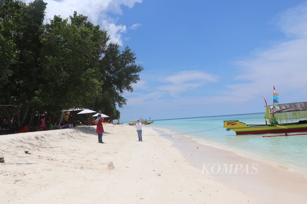Para pengunjung berfoto di Pantai Tanjung Waka, Desa Fatkauyon, Kecamatan Sulabesi Timur, Kepulauan Sula, Maluku Utara. Obyek wisata tersebut memiliki garis pantai yang panjang dengan pasir putih yang halus.