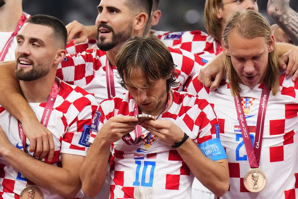 Pemain Kroasia, Luka Modric, mencium medali seusai pertandingan perebutan tempat ketiga Piala Dunia Qatar di Stadion Khalifa, Doha, Sabtu (17/12/2022). Kroasia merebut peringkat ketiga dengan mengalahkan Maroko, 2-1. 