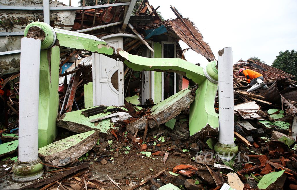 Sukarelawan membantu warga membersihkan rumahnya dari puing-puing bangunan yang rusak karena gempa bumi bermagnitudo 5,6 di Desa Sukamulya, Kecamatan Cugenang, Kabupaten Cianjur, Jawa Barat, Sabtu (26/11/2022).