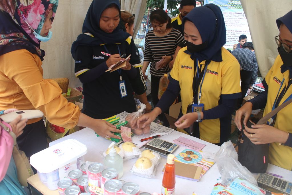 Warga bertransaksi dengan petugas gerai untuk membeli kebutuhan harian di pasar murah Lapangan Gasmin, Kecamatan Antapani, Kota Bandung, Jawa Barat, Kamis (22/9/2022).