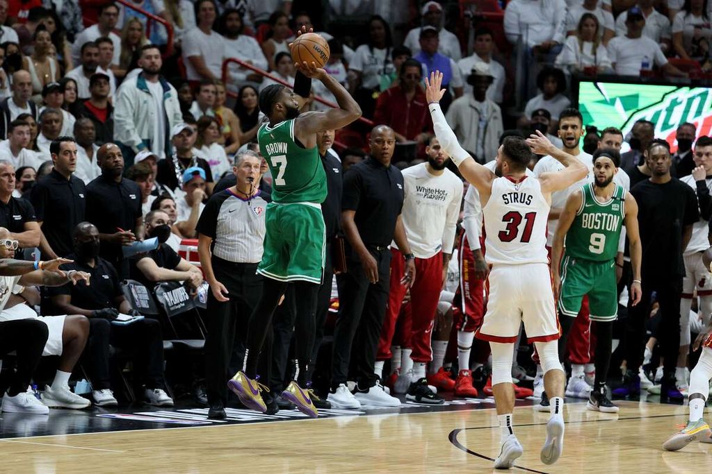 Jaylen Brown (kiri), <i>shooting guard</i> Boston Celtics, melompat untuk melempar tiga angka melewati penjagaan pemain Miami Heat, Max Strus, pada laga ketujuh final Wilayah Timur di FTX Arena, Miami, Florida, Senin (30/5/2022) pagi WIB. Brown mencetak 24 poin dan membawa Celtics mengalahkan Miami Heat, 100-96.