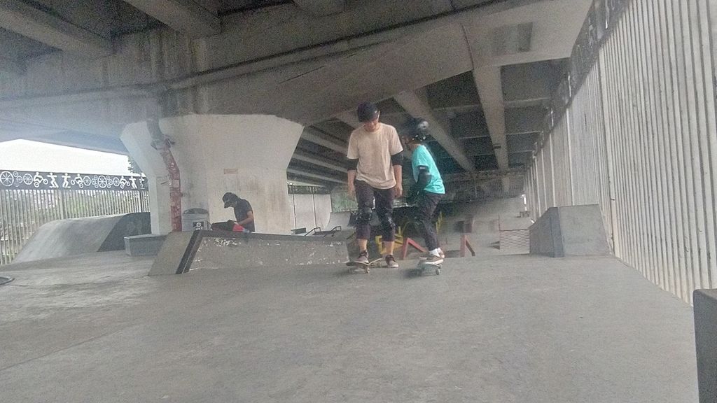 Yudhi (40) sedang mengajari anaknya bermain skateboard di Skatepark Pasar Rebo, Cijantung, Jakarta Timur, Minggu (30/10/2022).