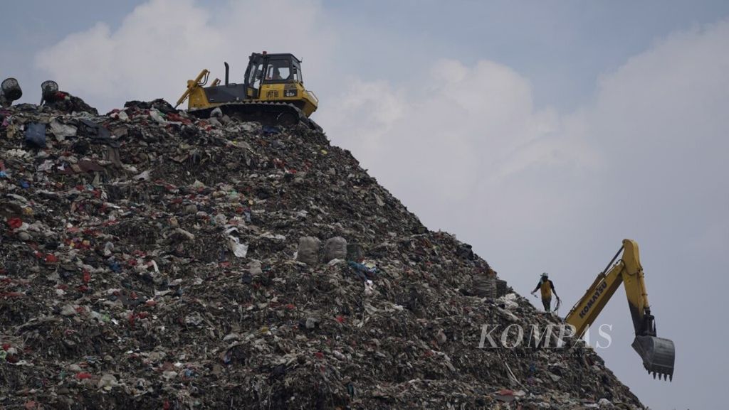 Pemulung menyortir sampah yang diratakan alat berat di Tempat Pengelolaan Sampah Terpadu Bantargebang, Bekasi, Jawa Barat, Jumat (14/6/2019). 