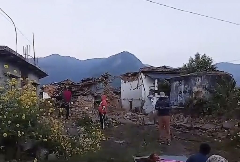 Foto tangkapan gambar video ini memperlihatkan warga sebuah desa di Jajarkot, Nepal, berdiri di luar rumah setelah gempa bermagnitudo 6,2 mengguncang wilayah tersebut, Jumat (3/11/2023) malam. Sedikitnya 132 orang tewas akibat gempa itu.  