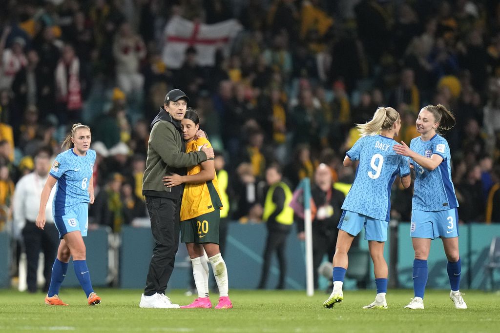 Pelatih tim putri Australia, Tony Gustavsson, memeluk kapten Australia, Sam Kerr, seusai Australia dikalahkan Inggris pada laga semifinal Piala Dunia Putri 2023 di Stadion Australia, Sydney, Australia, Rabu (16/8/2023).
