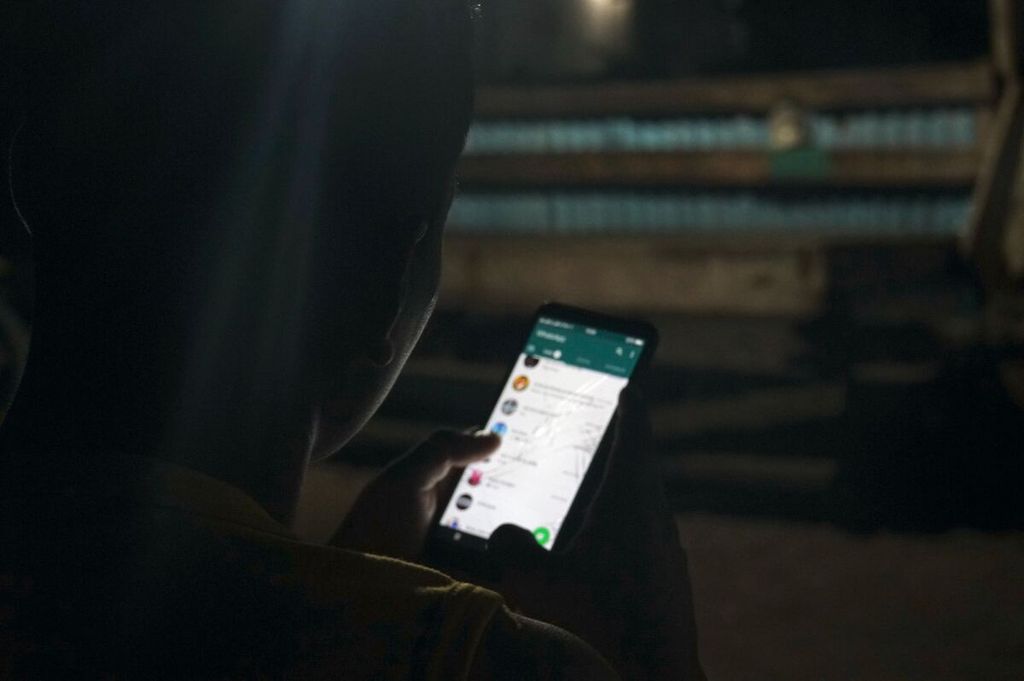 Desta (23), anggota TNI AD di Pos Angkatan Darat Miangas, Kepulauan Talaud, Sulawesi Utara, mengecek pesan di aplikasi Whatsapp pada Sabtu (14/3/2020) malam. Adakalanya sinyal tidak stabil di Miangas sehingga pesan singkat Whatsapp tidak dapat diterima.