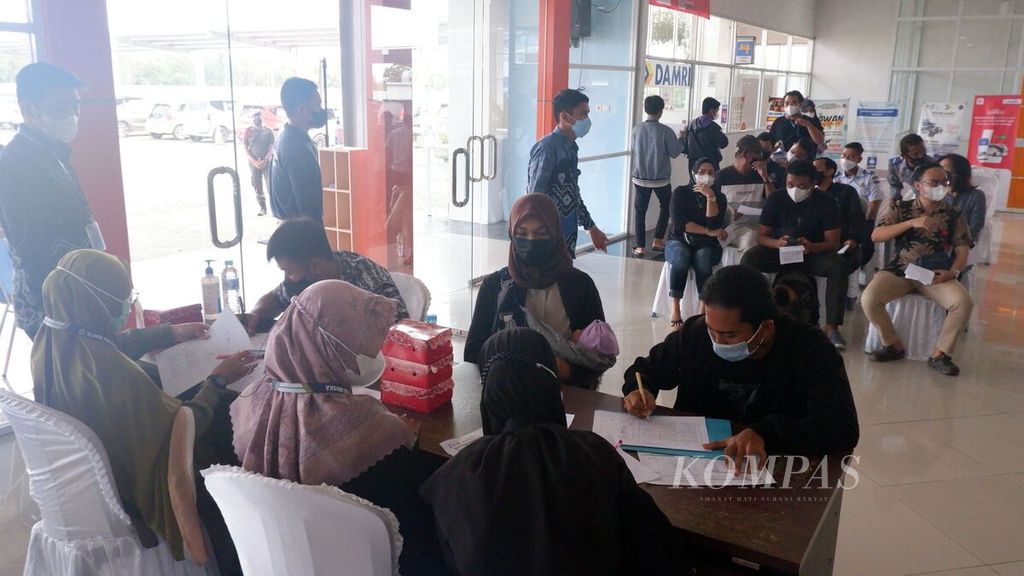 Warga antre untuk mengikuti vaksinasi dosis ketiga atau penguat (<i>booster</i>) di Terminal Tipe A Gambut Barakat, Kabupaten Banjar, Kalimantan Selatan, Selasa (15/3/2022).