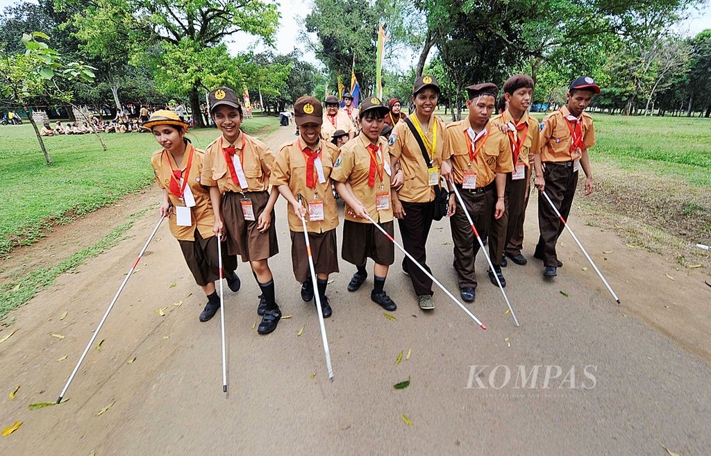 Sejumlah peserta tunanetra berjalan bersama saat mengikuti orientasi lapangan pada Pertemuan Pramuka Luar Biasa Nasional 2013 di Bumi Perkemahan Pramuka, Cibubur, Jakarta, Senin (1/7/2013). 