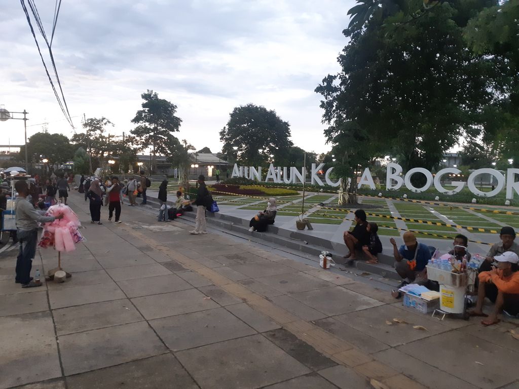 Warga masih bisa menikmati pemandangan Alun-alun Kota Bogor dari luar. Kedatangan warga menjadi kesempatan pedagang kaki lima menjajakan dagangannya, Jumat (7/1/2022).