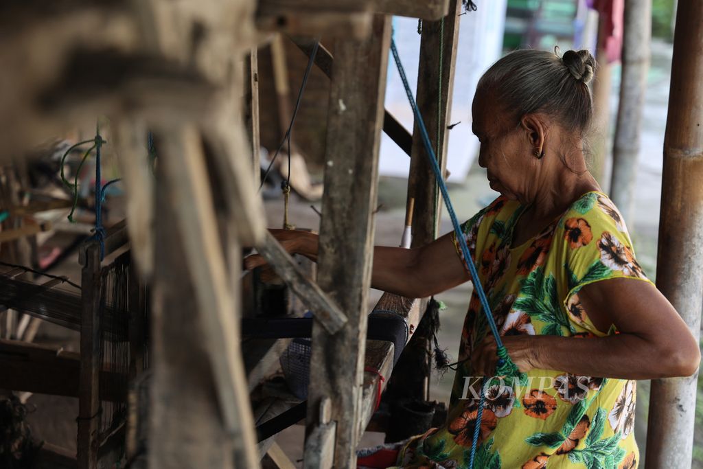 Seorang perempuan menggarap setagen menggunakan alat tenun bukan mesin di Dusun Blimbing, Desa Luwang, Gatak, Sukoharjo, Jawa Tengah, Senin (11/4/2022). 