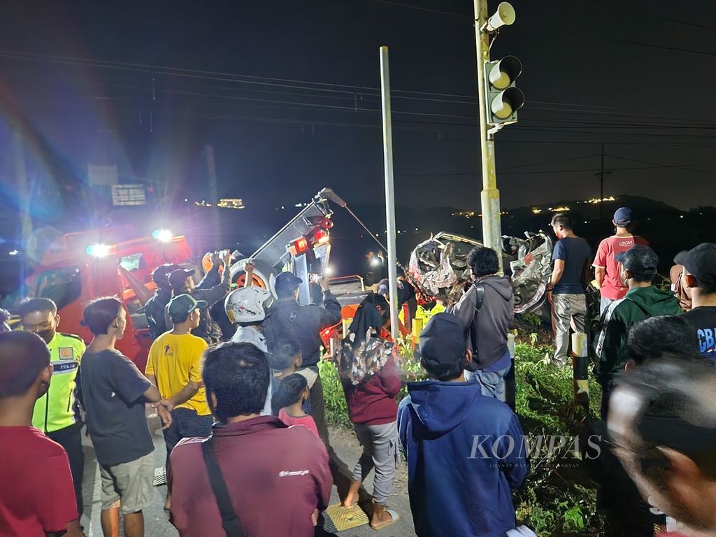 Warga menyaksikan proses evakuasi mobil yang ringsek akibat tertabrak Kereta Api Gaya Baru Malam Selatan di Kabupaten Klaten, Jawa Tengah, Minggu (14/1/2024). 