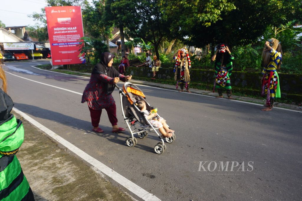 Seorang ibu mendorong kereta bayi di lintasan Borobudur Marathon 2022 Powered by Bank Jateng di Kawasan Candi Borobudur, Magelang, Jawa Tengah, Sabtu (12/11/2022).