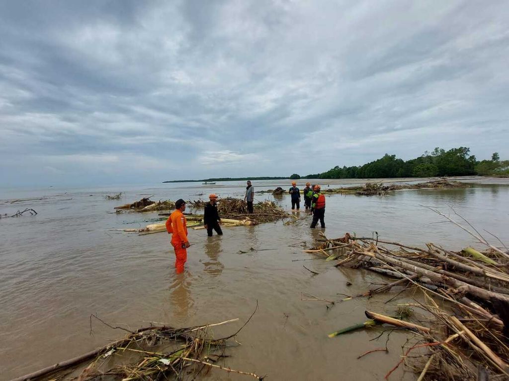 Tim pencarian menyisir tumpukan kayu di muara untuk mencari empat korban hilang akibat banjir bandang di Desa Torue, Kecamatan Torue, Kabupaten Parigi Moutong, Sulawesi Tengah, Sabtu (30/7/2022).