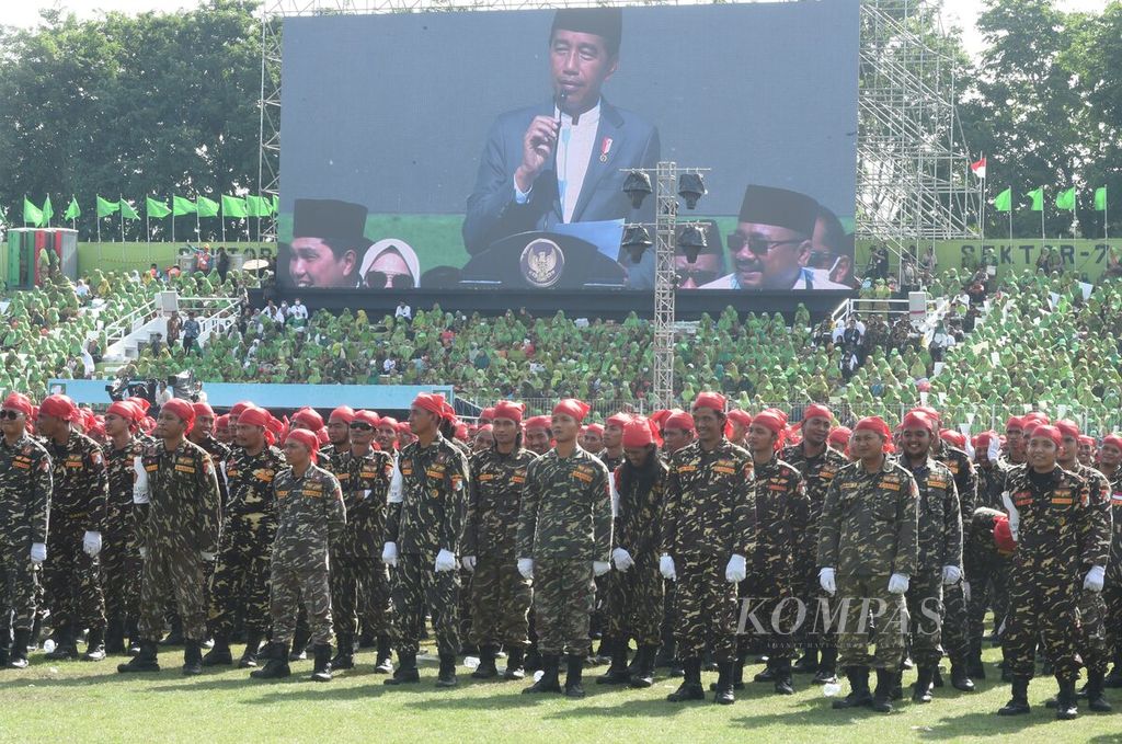 Presiden Joko Widodo terlihat di layar ketika memberikan kata sambutan saat puncak resepsi Satu Abad Nahdlatul Ulama di  Sidoarjo, Jawa Timur, Selasa (7/2/2022).  
