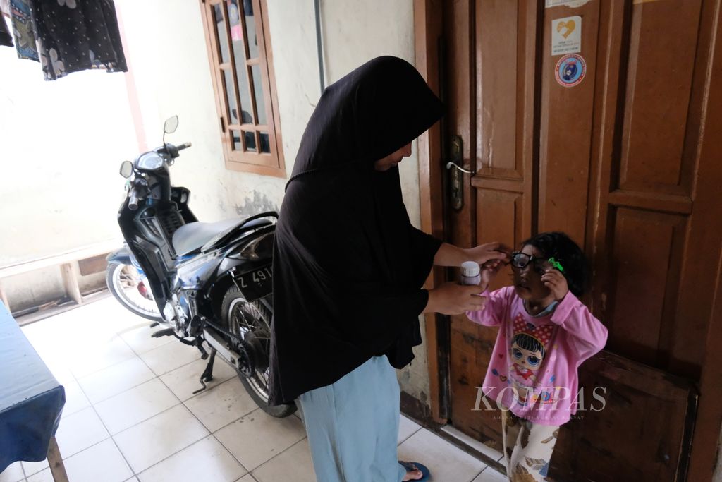 Nasihatul Karomah (26, kiri) memberikan sebotol susu kepada anaknya yang berumur 3 tahun 11 bulan, Sabtu (8/4/2023) di rumahnya di Kelurahan Cakung Barat, Kecamatan Cakung, Jakarta Timur. Anaknya didiagnosis mengalami <i>stunting</i> atau tengkes sekitar 6 bulan lalu setelah berat badannya terus turun.