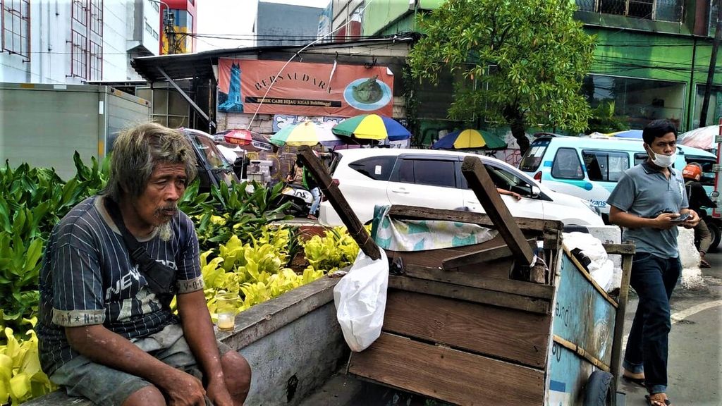 Ubad (58)  beristirahat di tengah perjalanan mengumpulkan botol plastik dan kardus di kawasan Pasar Jaya Tanah Abang hingga Bundaran HI, Jakarta Pusat, Rabu (26/10/2022).