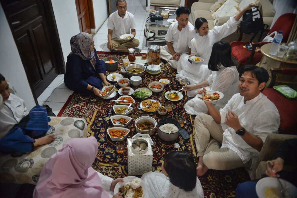 Beberapa anggota keluarga makan bersama di ruang tamu salah satu rumah di kawasan Petukangan Utara, Pesanggrahan, Jakarta Selatan, Sabtu (22/4/2023). Hari raya Idul Fitri menjadi salah satu momentum umat Islam untuk saling bermaaf-maafan dan bersilaturahmi kepada keluarga dan sahabat terdekat. 