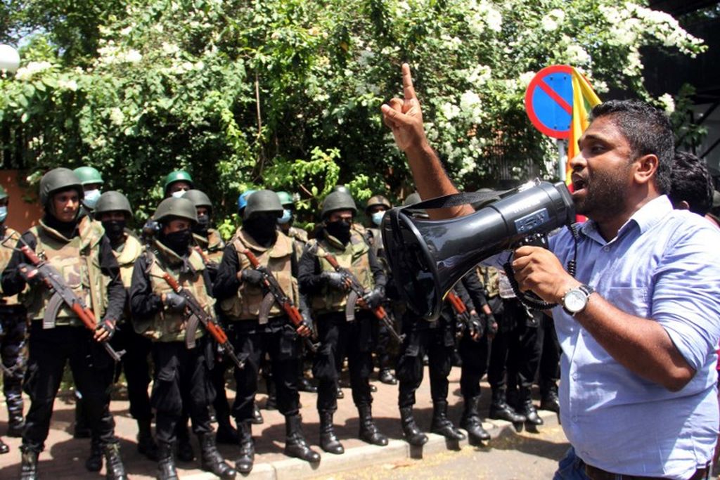Seorang demonstran menggunakan megafon ketika personel militer berjaga di luar kantor Perdana Menteri Sri Lanka dalam unjuk rasa anti-pemerintah di Colombo, Sri Lanka, Rabu, 13 Juli 2022. 