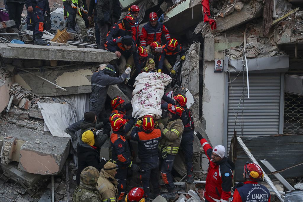 Tim pencari dan penyelamat mengevakuasi Ergin Guzeloglan (36) ke ambulans setelah berhasil menyelamatkannya dari puing-puing bangunan yang kolaps akibat gempa di daerah Hatay, Turki, Sabtu (11/2/2023) atau lima hari setelah gempa. 