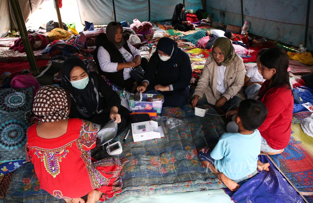 Tim medis gabungan dari Cipanas memeriksa kesehatan para pengungsi korban gempa bumi yang tinggal di tenda pengungsian di Kampung Cibereum, Desa Cikanyere, Kecamatan Sukaresmi, Kabupaten Cianjur, Jawa Barat, Minggu (27/11/2022). Hingga hari ketujuh pascagempa bermagnitudo 5,6 di Cianjur, sebanyak 62.870 orang masih mengungsi. Adapun rumah rusak tercatat 58.049.