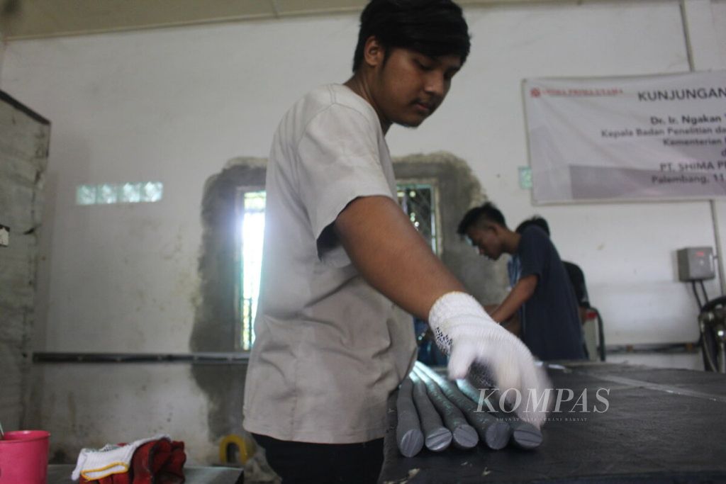 Dua pekerja sedang menyusun kompon karet berbentuk selang di pabrik milik PT Shima Prima Utama di Palembang, Sumatera Selatan, Senin (11/3/2019). 