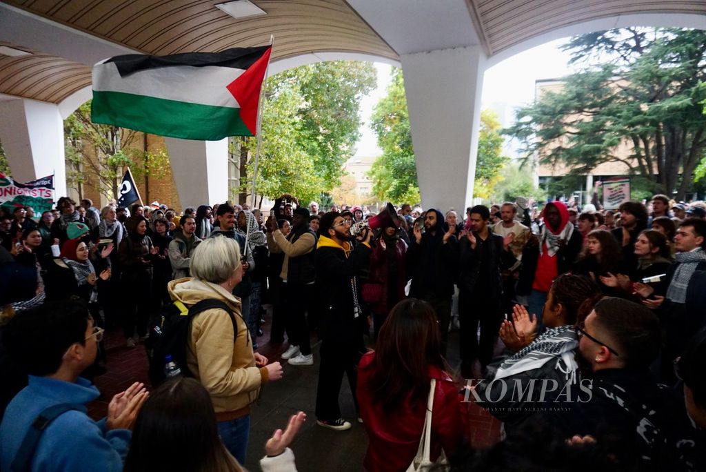 Ratusan mahasiswa menyanyikan slogan pembebasan Palestina dalam protes di kampus Parkville Universitas Melbourne, Australia, Senin (29/4/2024), untuk meminta penghentian kerja sama perguruan tinggi tersebut dengan beberapa perusahaan yang memasok senjata ke Israel. 