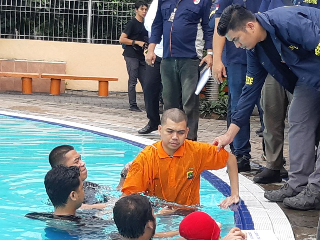 Yudha Arfandi (baju jingga) mengikuti tahapan rekonstruksi kematian Raden Adante Khalif Pramudityo atau Dante di Kolam Renang Taman Air Tirtamas, Jakarta Timur, Rabu (28/2/2024). Rekonstrusi ini digelar untuk membuat terang kronologi peristiwa. 