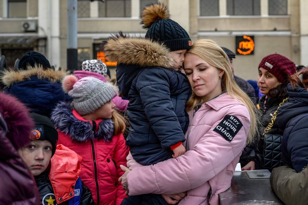 Seorang perempuan memeluk seorang anak saat menanti di stasiun utama kereta di kota pelabuhan Odessa, Ukraina, Rabu (9/3/2022), untuk mengungsi.  