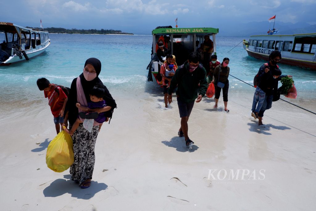 Para penumpang turun dari kapal begitu tiba di Gili Trawangan, Lombok Utara, Nusa Tenggara Barat, Sabtu (14/11/2020). Saat ini, kegiatan pariwisata di Trawangan termasuk dua gili lain yakni Meno dan Air, sudah dibuka kembali. Penerapan protokol kesehatan tetap dilakukan.