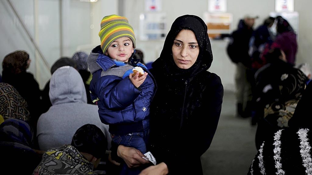 Seorang bocah Suriah makan roti di gendongan ibunya saat keduanya mengantre untuk mendaftar di kantor Komisi Tinggi Urusan Pengungsi PBB (UNHCR) di Beirut, Lebanon, 30 Januari 2017. 