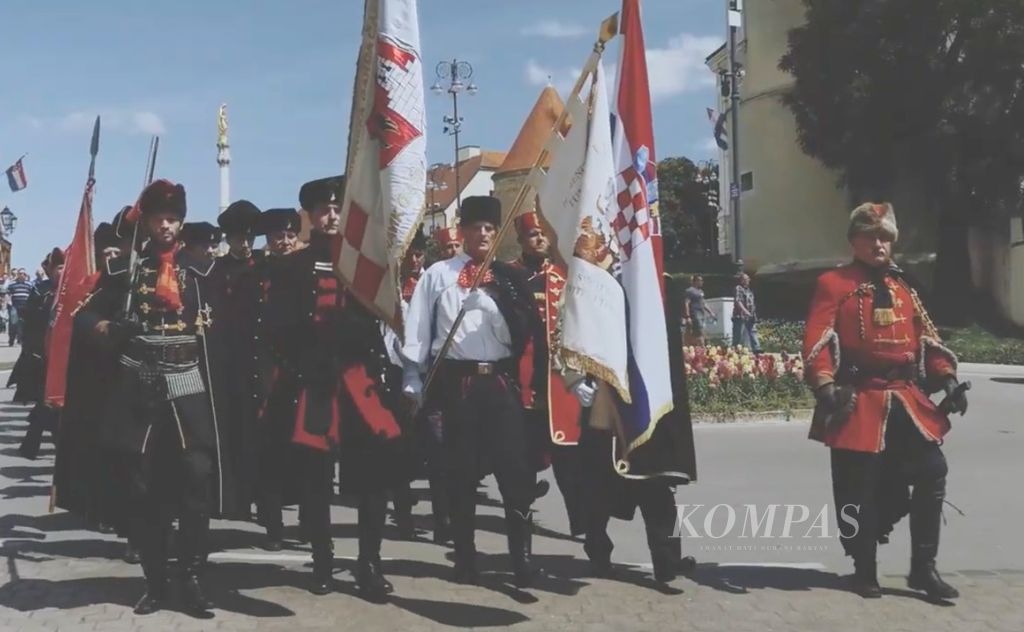 Dalam tangkapan layar dari video yang disiarkan Badan Promosi Pariwisata Zagreb pada Mei 2017 ini, warga Zagreb, Kroasia mengikuti pawai dengan mengenakan busana anggota resimen Cravat. Pada abad 17, resimen itu dikenal pula sebagai Resimen Kroasia karena seluruh anggotanya dari Kroasia. Resimen itu salah satu kelompok tentara bayaran dalam berbagai perang di Eropa. 