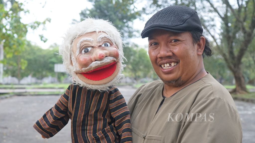 Pendongeng asal Palembang, Sumatera Selatan, Slamet Nugroho, berpose dengan boneka Mbah Jarwo yang selalu dipakai untuk mendongeng ke anak-anak.  