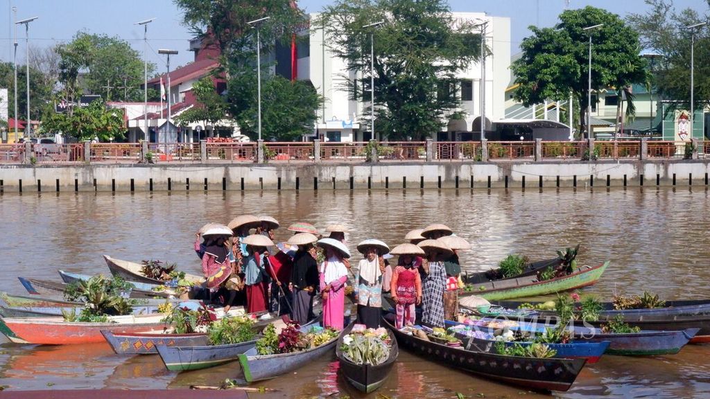 Para pedagang pasar terapung melakukan atraksi dengan membentuk formasi bunga teratai untuk menghibur tamu Women20 atau W20 Presidensi Indonesia, bagian dari G20 di Kota Banjarmasin, Kalimantan Selatan, Kamis (24/3/2022).