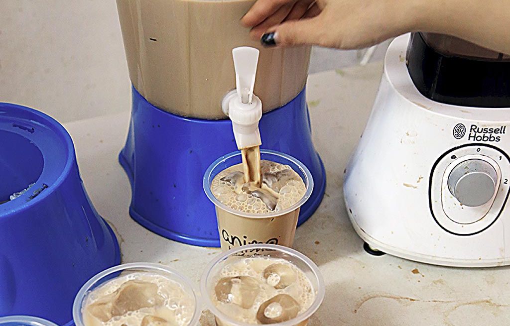 Staf Animo Bakery menyiapkan pesanan es kopi susu.